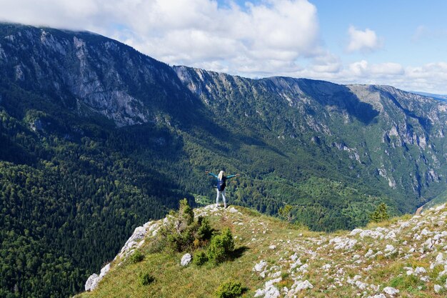 Foto de paisagem de uma cordilheira e um turista que olha para a beleza das montanhas