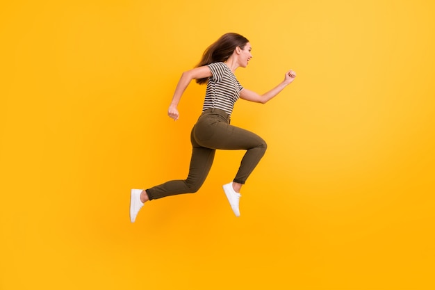 Foto de perfil de corpo inteiro de uma garota louca engraçada e funky, salto, corrida, use roupas bonitas isoladas sobre a parede de cores brilhantes