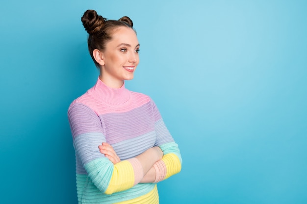 Foto de perfil de senhora atraente dois pãezinhos bom humor charmoso jovem bonito braços cruzados olhar lado espaço vazio vestir suéter listrado quente casual isolado fundo de cor azul