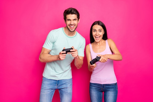 Foto de perfil de um casal engraçado e uma moça passando o fim de semana juntos jogando videogame. Melhor resma, roupa casual isolada cor de fundo rosa