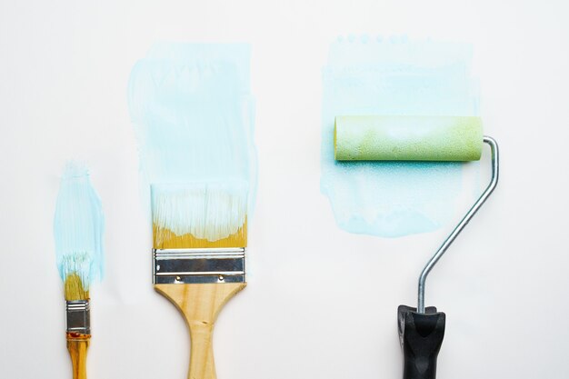 Foto de pincéis e rolos com tinta azul em fundo branco em branco