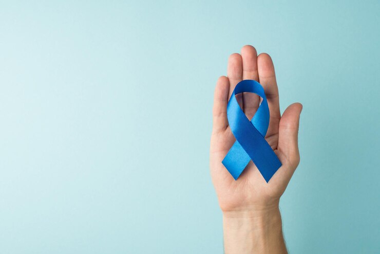 Foto foto de primeira pessoa da vista superior da mão do homem segurando a fita de cetim azul no símbolo da palma da conscientização do câncer de próstata em fundo azul pastel isolado com espaço vazio