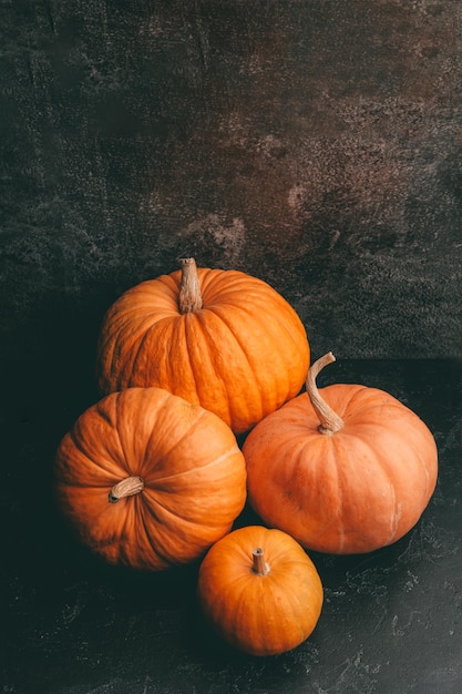 Foto de quatro abóboras laranja na celebração de halloween de fundo preto