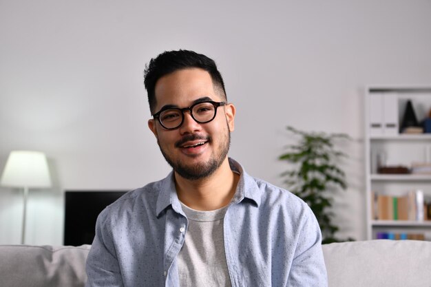 Foto de retrato de um empresário asiático amigável e confiante feliz fazendo videochamada, olhando para a câmera e conversando, discutindo estratégia com parceiros on-line em casa.