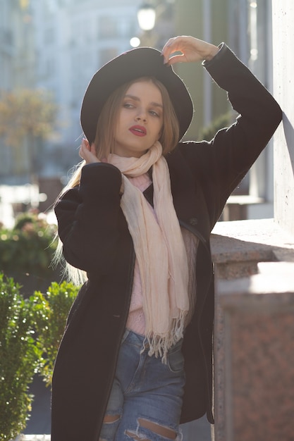 Foto de rua de glamour jovem usando chapéu e lenço, curtindo o clima