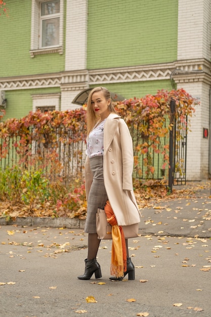 Foto de rua de uma jovem mulher bonita vestindo roupas clássicas à moda. Modelo olhando para baixo. Conceito de moda feminina.