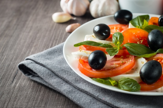Foto de Salada Caprese com tomate, manjericão, mussarela, azeitonas e azeite