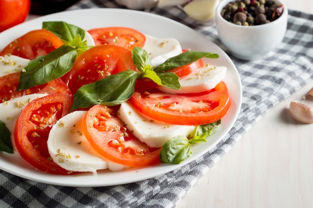 Foto de Salada Caprese com tomate, manjericão, mussarela, azeitonas e azeite