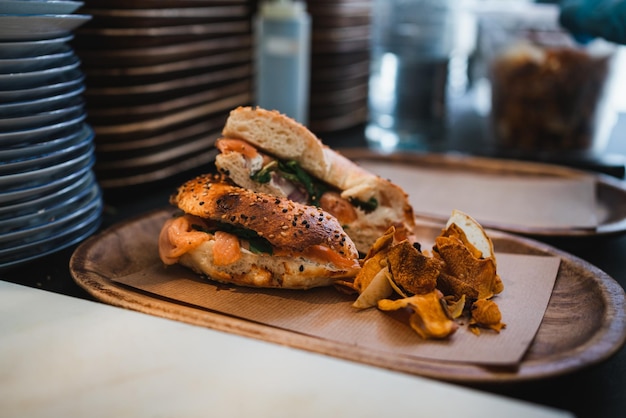 Foto de sanduíche de bagel de salmão com batatas fritas na cozinha pronta para ser servida ao cliente