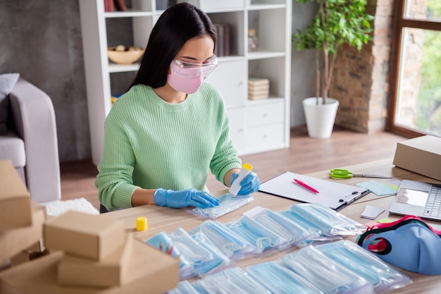 Foto de senhora chinesa ocupada empresa familiar organizando gripe facial máscaras médicas espalhamento global enviar pacotes de caridade países pobres preparar conjuntos seguros entrega escritório doméstico quarentena dentro