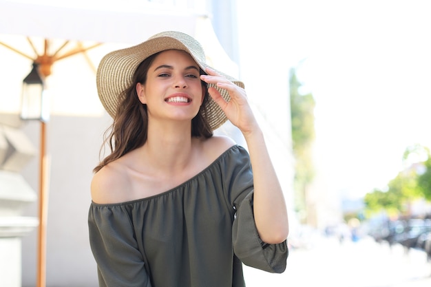 Foto de sorridente jovem linda mulher alegre está andando na rua da cidade.