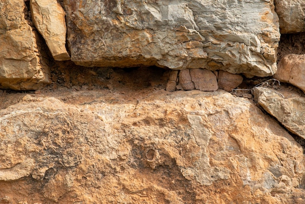 Foto de textura aproximada de rochas de uma montanha áspera com rachaduras e seixos