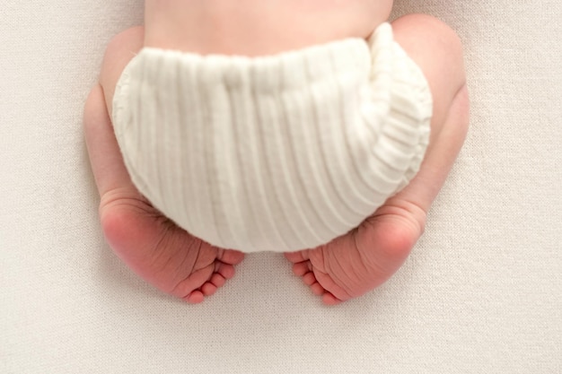 Foto de um bebê recém-nascido Pernas e corpo das crianças em calcinha de lã branca Dedos dos pés das crianças pés e calcanhares Foto de estúdio de alta qualidade em um fundo branco isolado