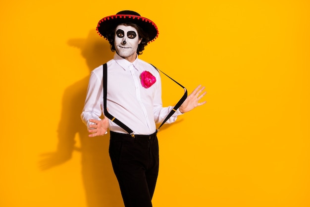 Foto de um cara zumbi assustador preparar dança latina festival espanhol rumba esperar parceiro vestir camisa branca rosa traje de morte sombrero suspensórios isolados de cor amarela