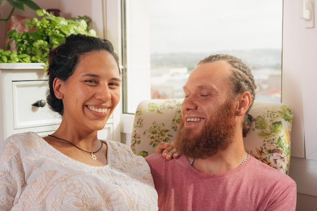 Foto foto de um casal alegre, feliz e descuidado, sorrindo, uma mulher morena atraente e com um penteado estiloso