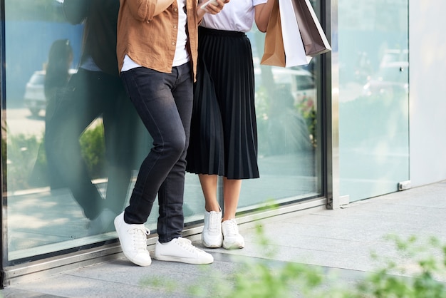 Foto de um casal fazendo compras com smartphone na cidade