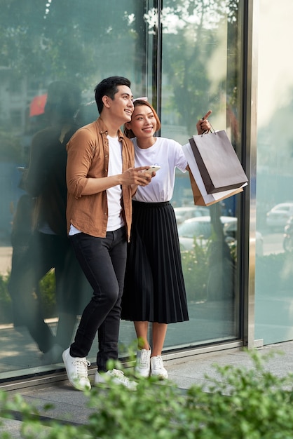 Foto de um casal fazendo compras com smartphone na cidade