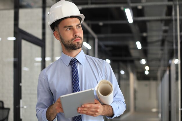 Foto de um engenheiro usando um tablet digital em uma construção.