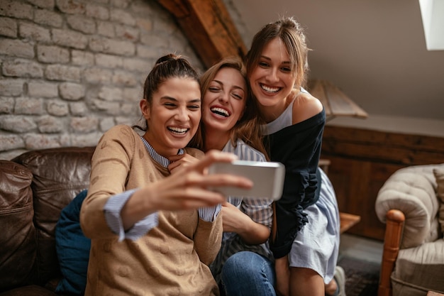 Foto de um grupo de amigas tirando uma selfie em casa