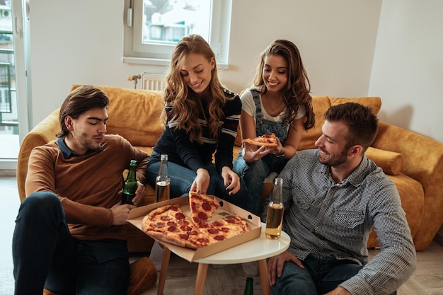 Foto de um grupo de amigos desfrutando de pizza juntos