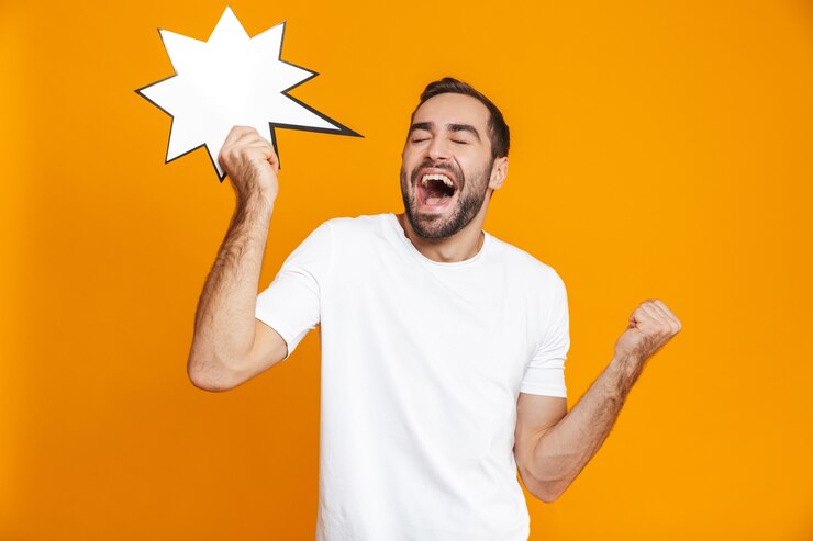 Foto foto de um homem alegre de 30 anos, em roupas casuais, segurando um anúncio de ideia em branco, isolado