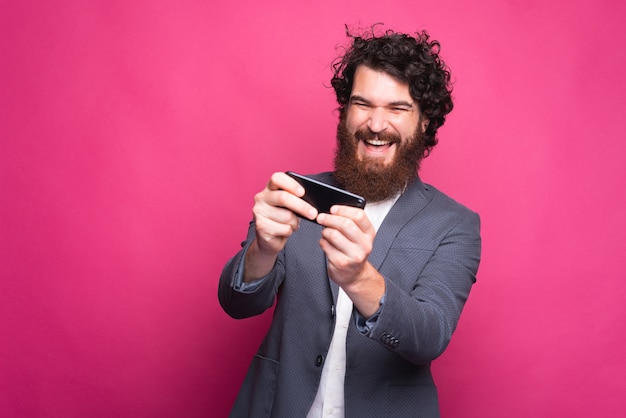 Foto de um homem de negócios barbudo alegre jogando no tempo livre