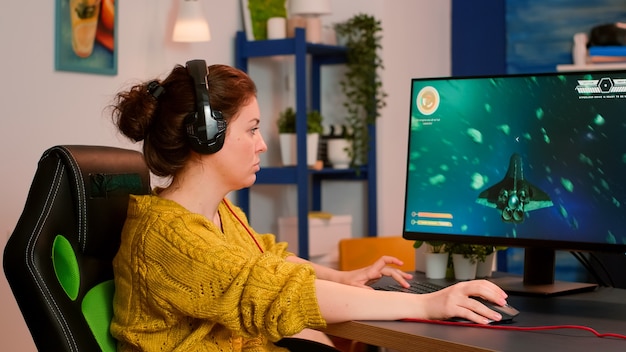 Foto de um jogador profissional jogando videogame on-line de atirador espacial no computador, campeonato cibernético de e-Sport