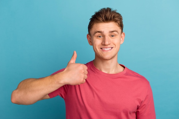 Foto de um jovem alegre mostra o polegar para cima aprova o feedback perfeito ideal isolado sobre o fundo azul