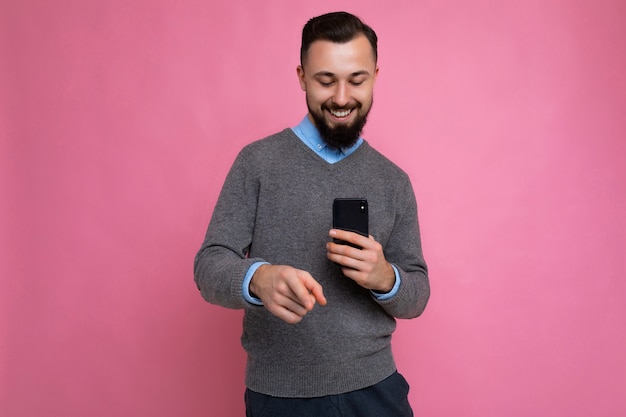 Foto foto de um jovem bonito, positivo e bonito, vestindo uma roupa casual elegante, posando