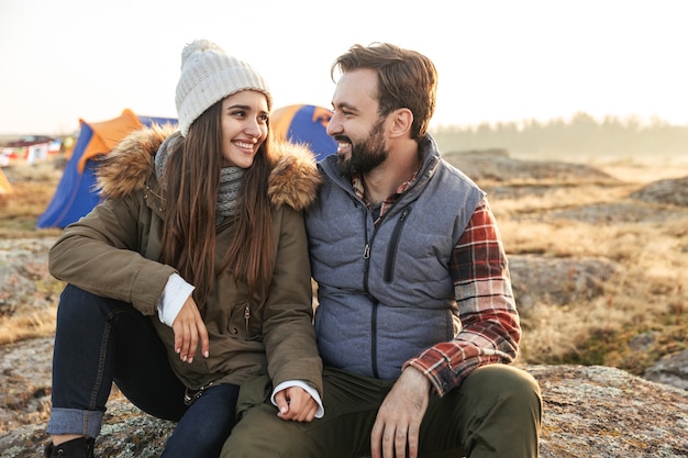 Foto de um jovem casal amoroso feliz do lado de fora com uma barraca em acampamento alternativo de férias nas montanhas.