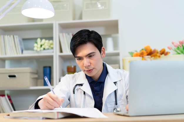 Foto de um jovem médico asiático trabalhando no escritório