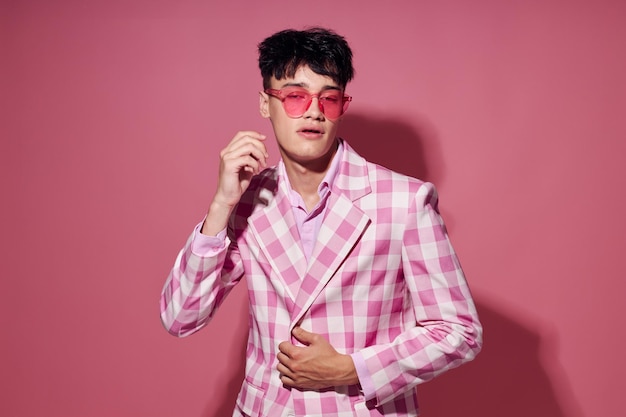 Foto de um jovem namorado romântico em óculos cor de rosa blazer rosa posando estúdio rosa fundo inalterado