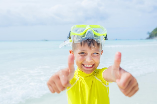 Foto de um menino feliz com snorkel em um maiô amarelo