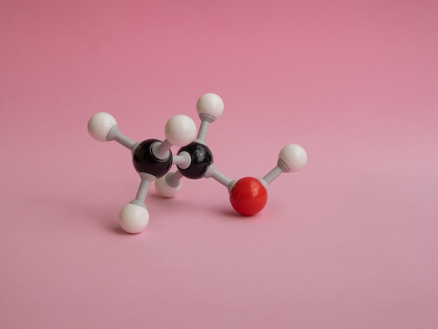 Foto de um modelo de átomo molecular isolado em um fundo rosa.