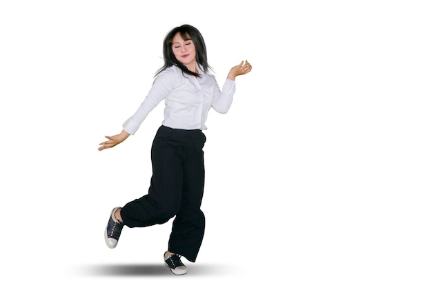 Foto de uma empreendedora feliz dançando no estúdio enquanto usava terno formal isolado em fundo branco