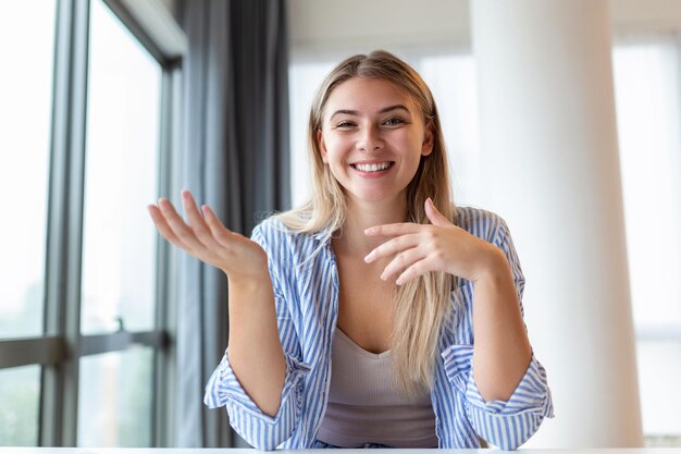 Foto de uma empresária em uma videochamada enquanto está sentada em sua mesa Foto recortada de uma jovem atraente usando seu laptop para fazer uma videochamada em casa