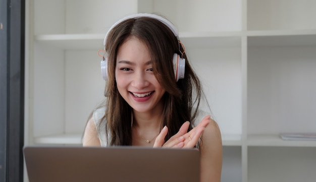 Foto de uma empresária sorridente olhando para a webcam fazendo uma teleconferência