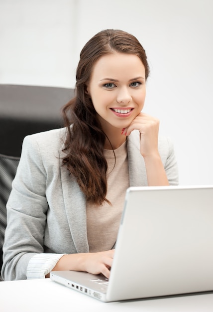 Foto de uma empresária sorridente usando seu laptop