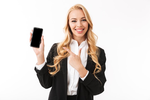 Foto de uma encantadora empresária vestindo terno de escritório, sorrindo, segurando um smartphone com tela preta