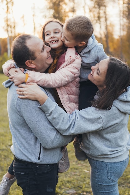 Foto foto de uma família de pé juntos no parque posando enquanto olham uns para os outros pessoas felizes