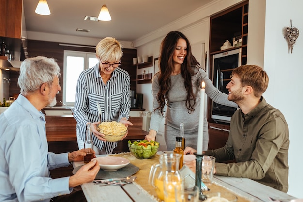 Foto de uma família fazendo uma refeição juntos em torno de uma mesa de jantar