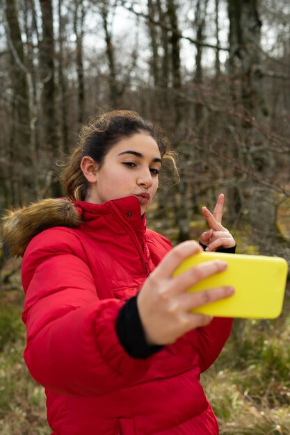 Foto de uma garota em um parque tirando uma selfie