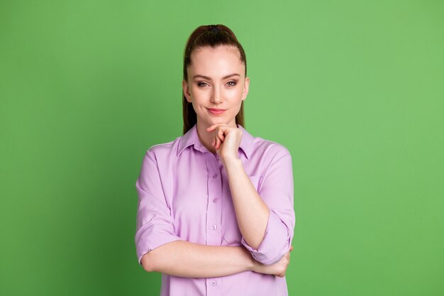 Foto de uma garota esperta e esperta, queixo de mão de toque de trabalhador, tem um plano de trabalho incrível, use roupas de boa aparência isoladas sobre o fundo de cor verde