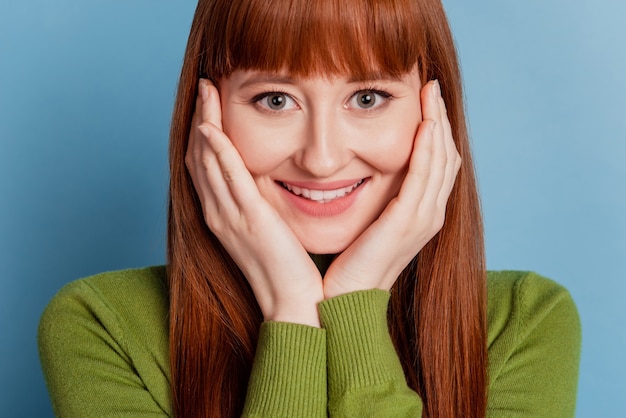 Foto de uma jovem alegre com um sorriso radiante isolada em um fundo azul