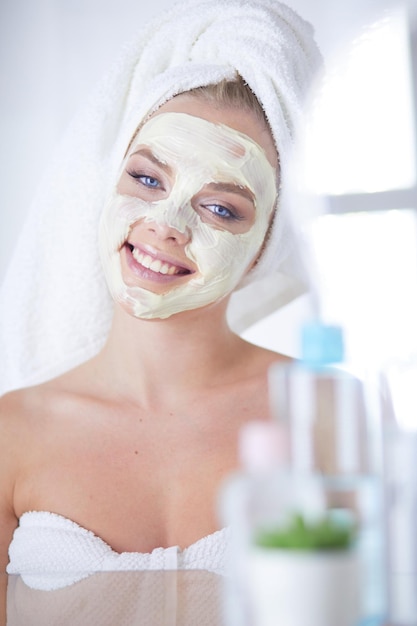 Foto de uma jovem aplicando pó facial no banheiro