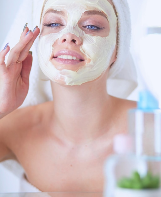 Foto de uma jovem aplicando pó facial no banheiro