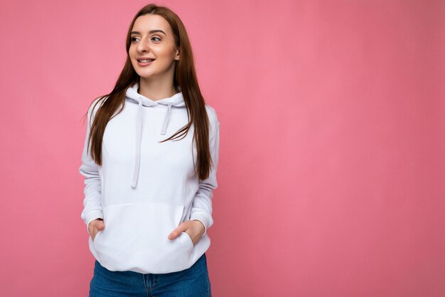 Foto de uma jovem atraente feliz e sorridente, vestindo uma roupa casual, isolada sobre o colorido