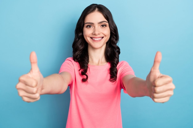 Foto de uma jovem bonita e alegre mostra a promoção de anúncio de polegar para cima aprova grande isolado sobre fundo de cor azul