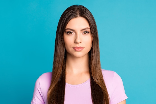 Foto de uma jovem confiante vestindo uma camiseta casual violeta com fundo de cor azul isolado