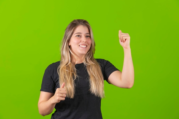 Foto de uma jovem em êxtase gritando bem alto sim levantando o punho ganhando na loteria isolada fundo de cor brilhante